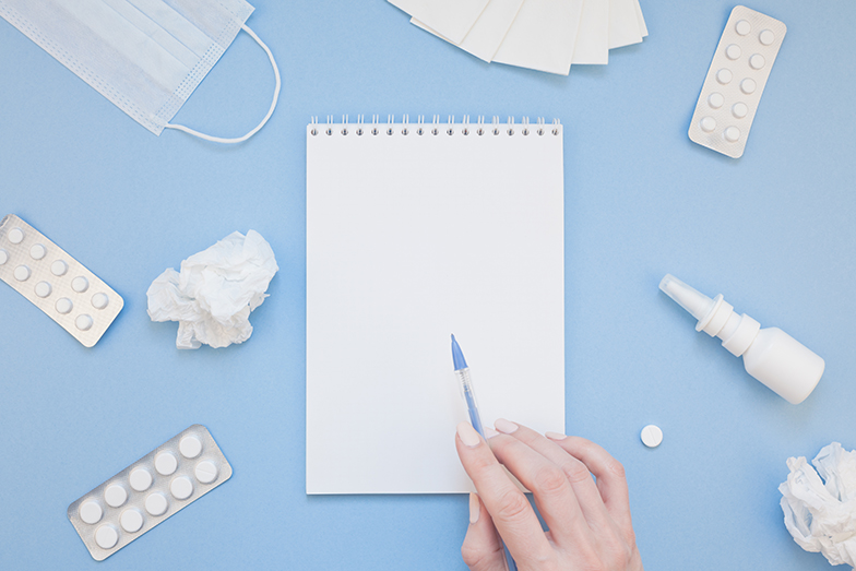 Creative flat lay concept of seasonal spring allergy with napkins, pills, face mask, drops in a bottle and a female hand with copy space background minimal style, template for text
