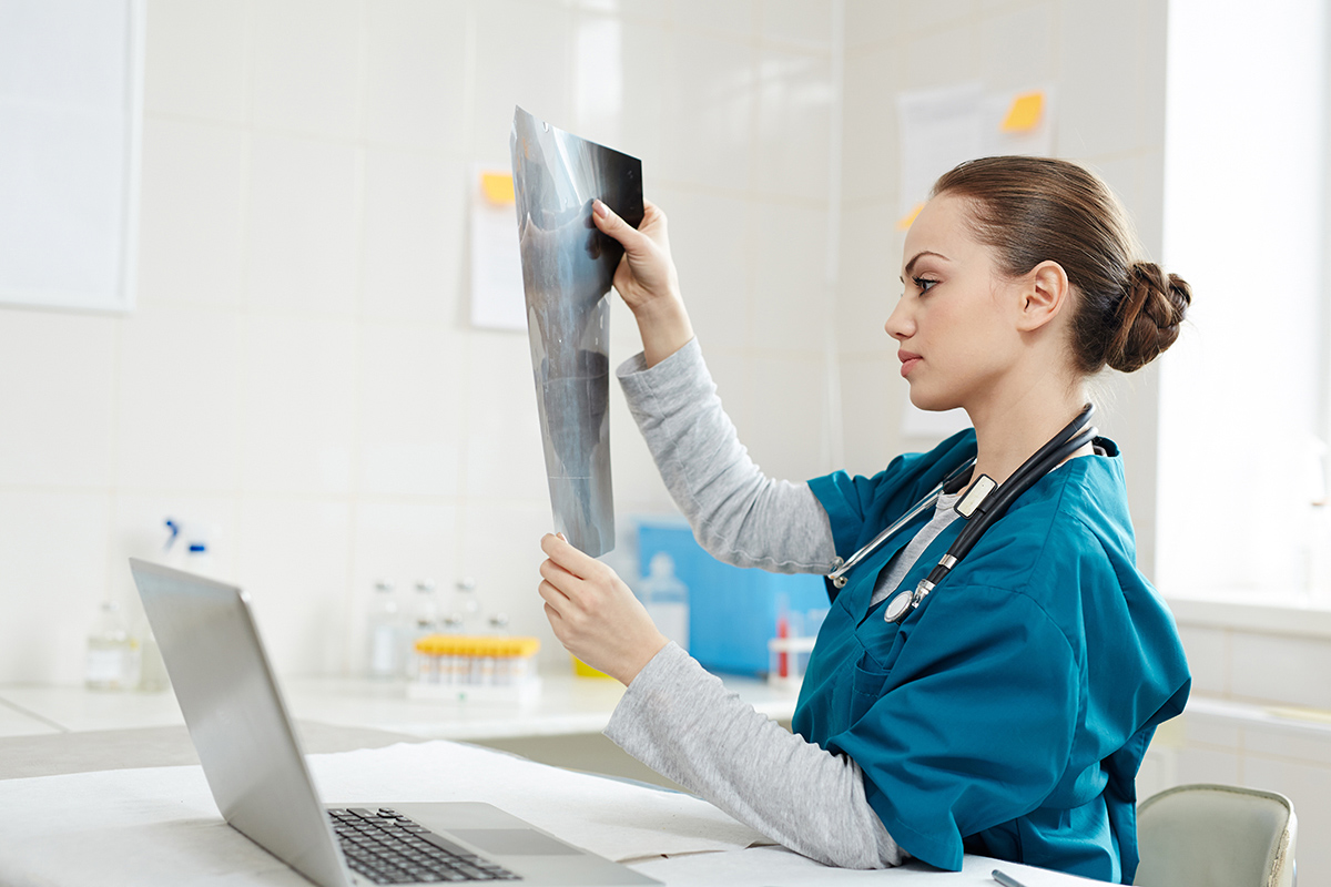Prevention is better than cure. Shot of a young doctor examining Prevention is better than cure. Shot of a young doctor examining an x-ray in an office