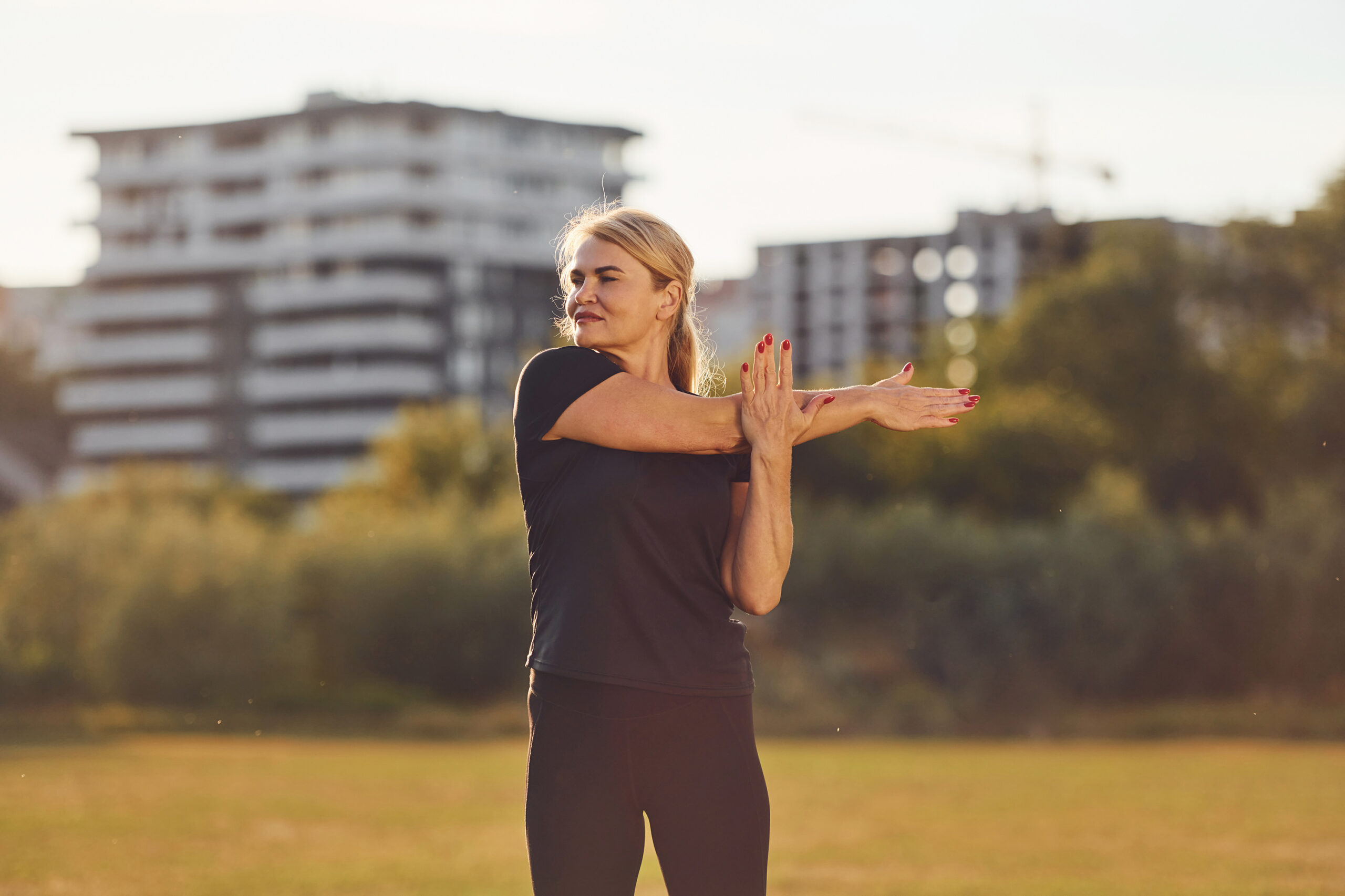 Fitness exercises. Mature sportive woman in fitness clothes is outdoors at daytime Fitness fitness services Working out physical physical well being physical strength strength training weight loss weight management muscle personal training strength training weight