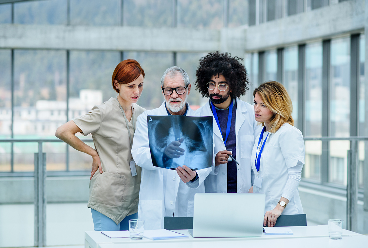 Group of doctors looking at X-ray on medical conference, discussing issues. Pulmonary pulmonary function testing breathing lungs