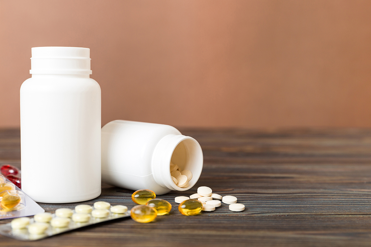 Medicine for treatment HIV infection. Pills and capsules and battle on the table. Different colorful tablets at colored background with copy space Medicine for treatment HIV infection. Pills and capsules and battle on the table. Different colorful tablets at colored background with copy space.