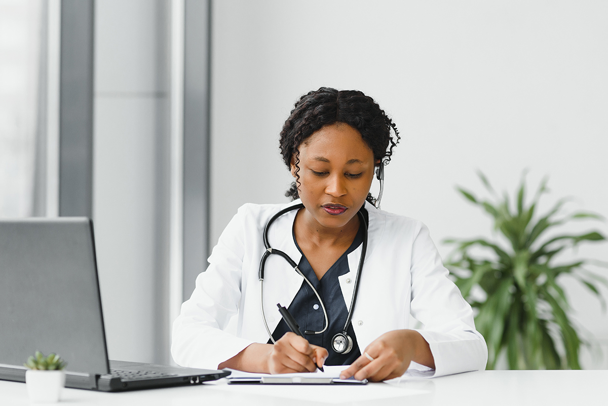 medicine, online service and healthcare concept – happy smiling african american female doctor or nurse with headset and laptop having conference or video call at hospital. medicine, online service and healthcare concept - happy smiling african american female doctor or nurse with headset and laptop having conference or video call at hospital