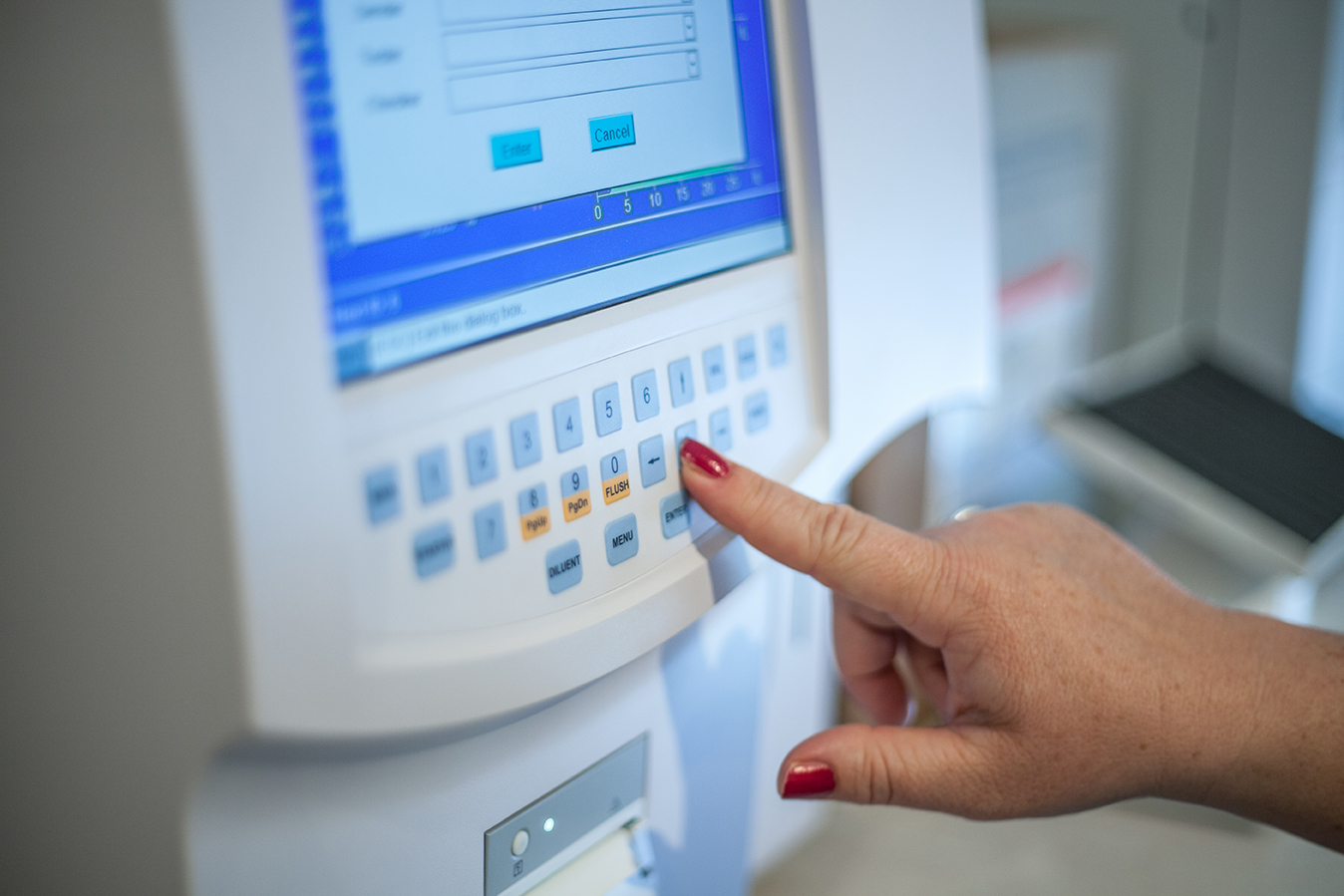 Selective focus shot of a female doctor adjusting the CBC (complete blood count) blood test machine A selective focus shot of a female doctor adjusting the CBC (complete blood count) blood test machine