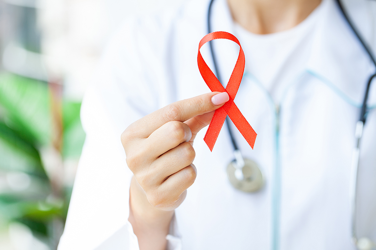Woman hand holding red ribbon HIV, world AIDS day awareness ribbon. Woman hand holding red ribbon HIV, world AIDS day awareness ribbon