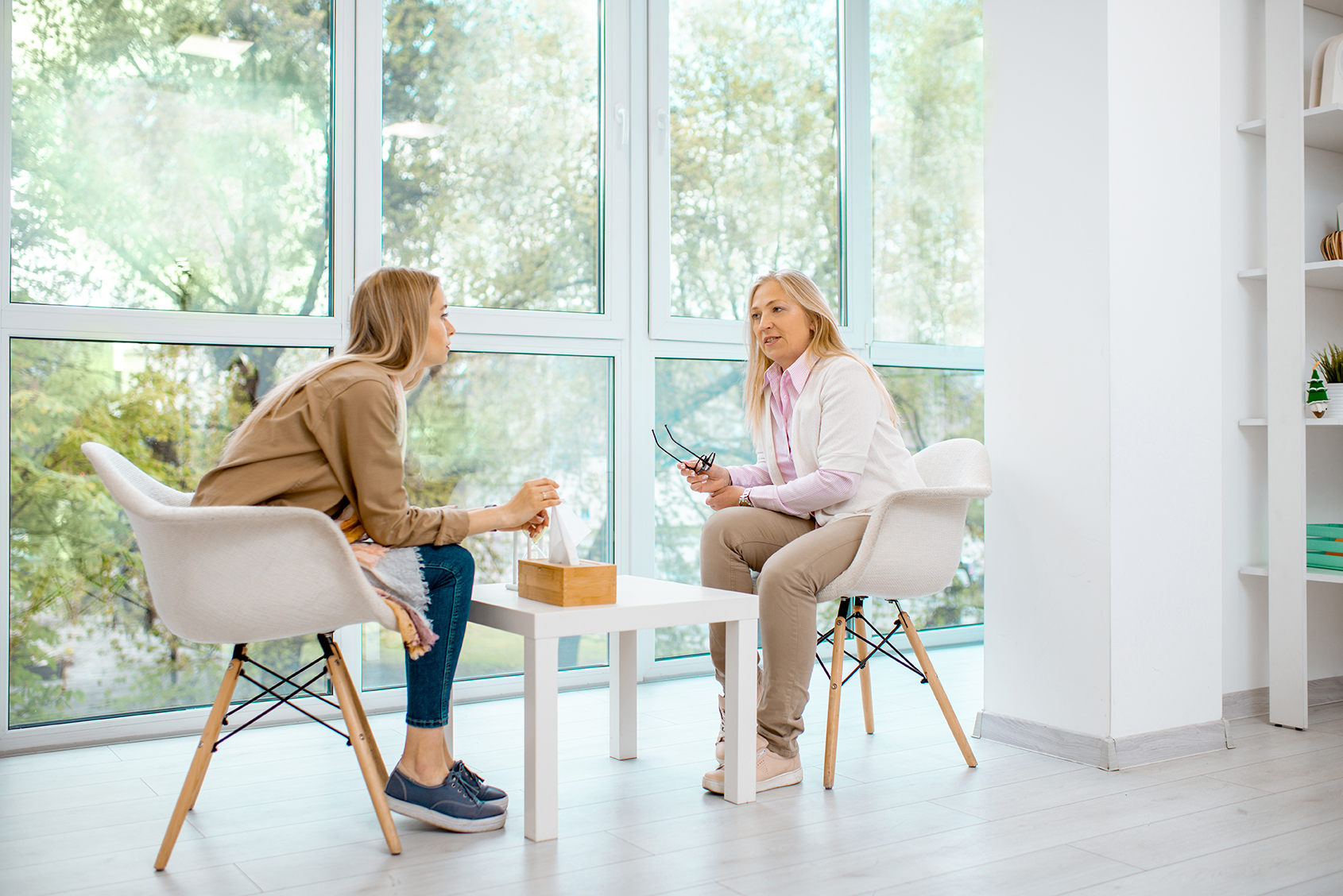 Woman with psychologist in the office Young woman with senior female psychologist or mental coach during the psychological counseling in the office