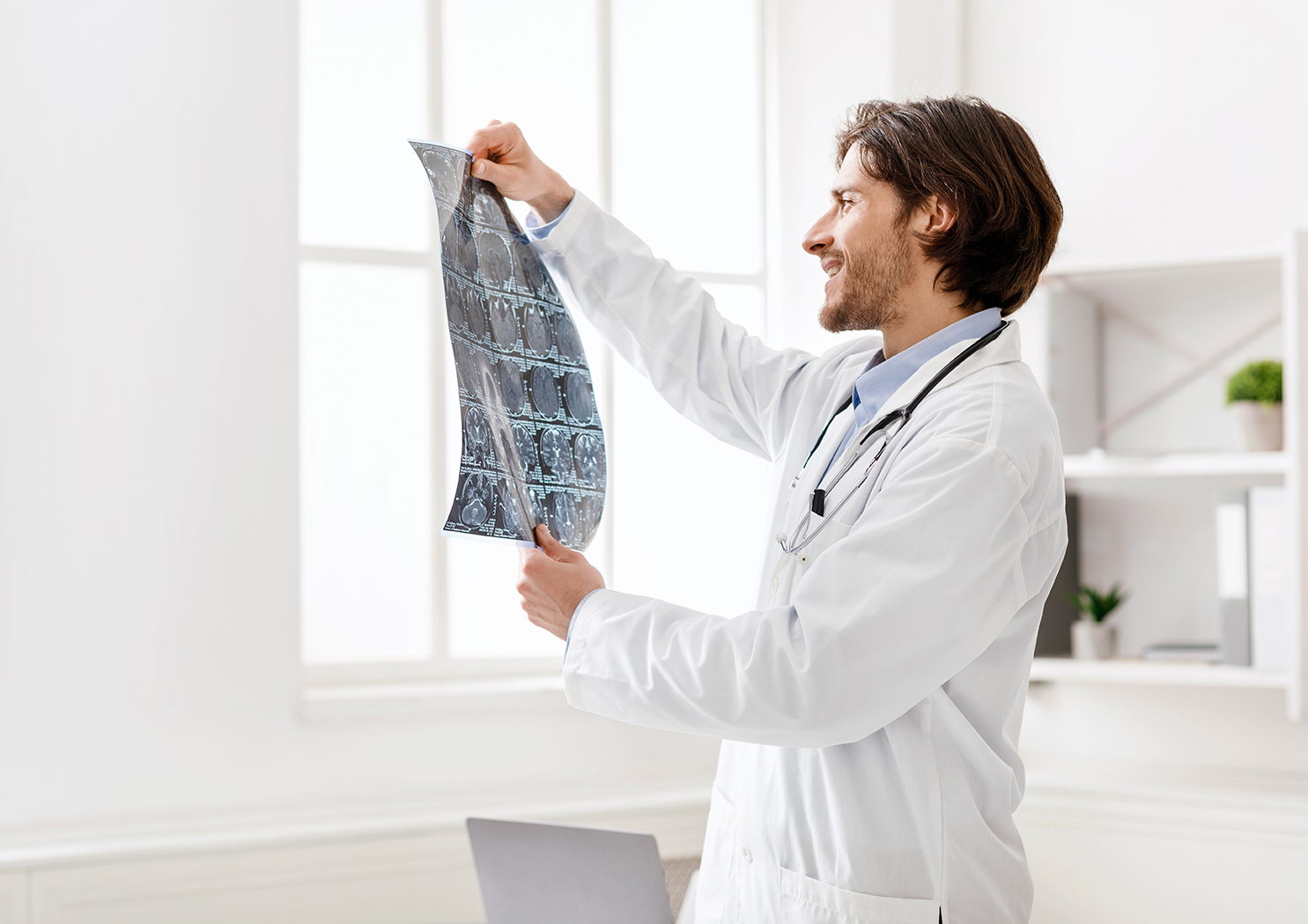 Young medical doctor checking good x-ray scans Young medical doctor checking good x-ray scans at office, free space