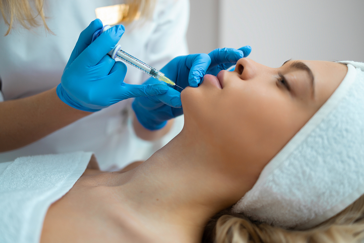Chin injection. Close up of a female face during the hyaluronic acid injection
