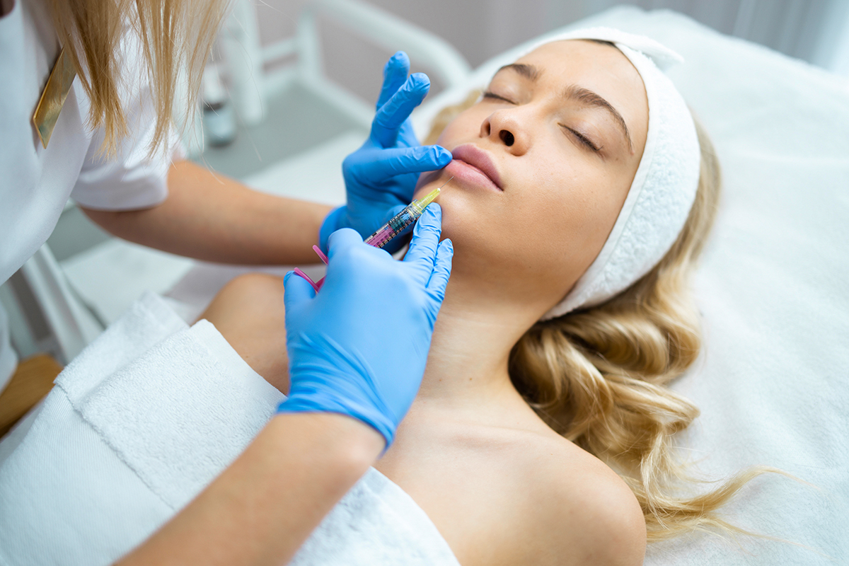 Lip augmentation procedure. Pretty woman getting beauty injection for lips