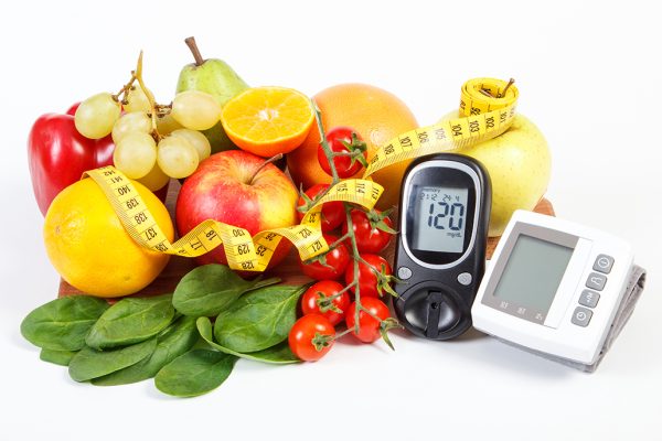 Glucose meter, blood pressure monitor, fresh fruits with vegetables and tape measure, healthy lifestyle, slimming, diabetes and prevention of hypertension concept